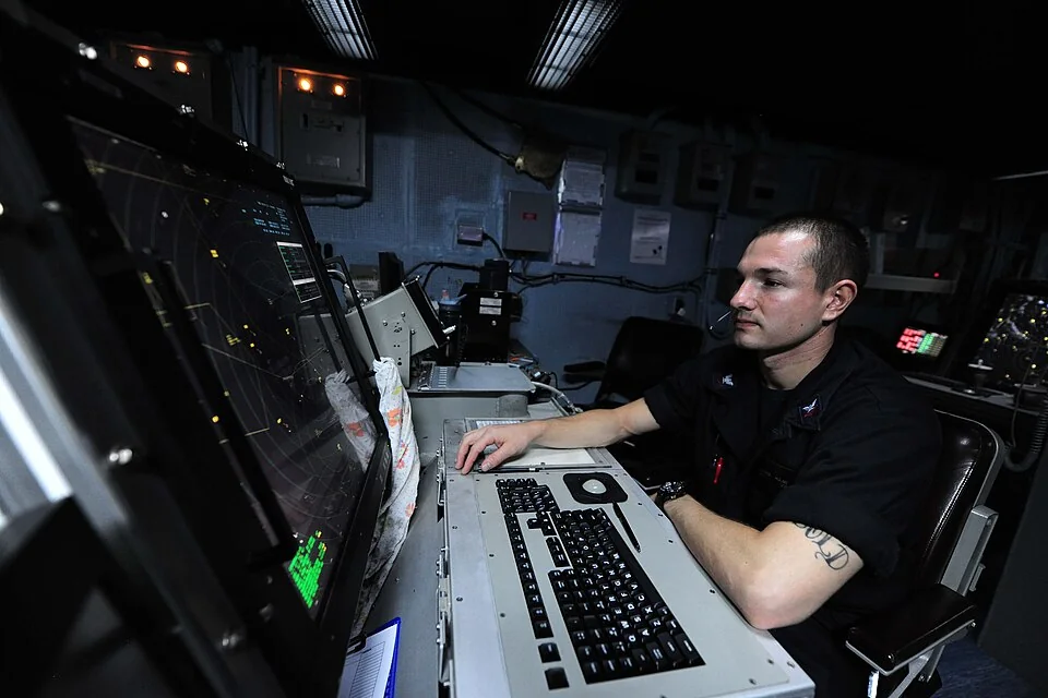 Naval controller monitoring operations from an aircraft carrier control center