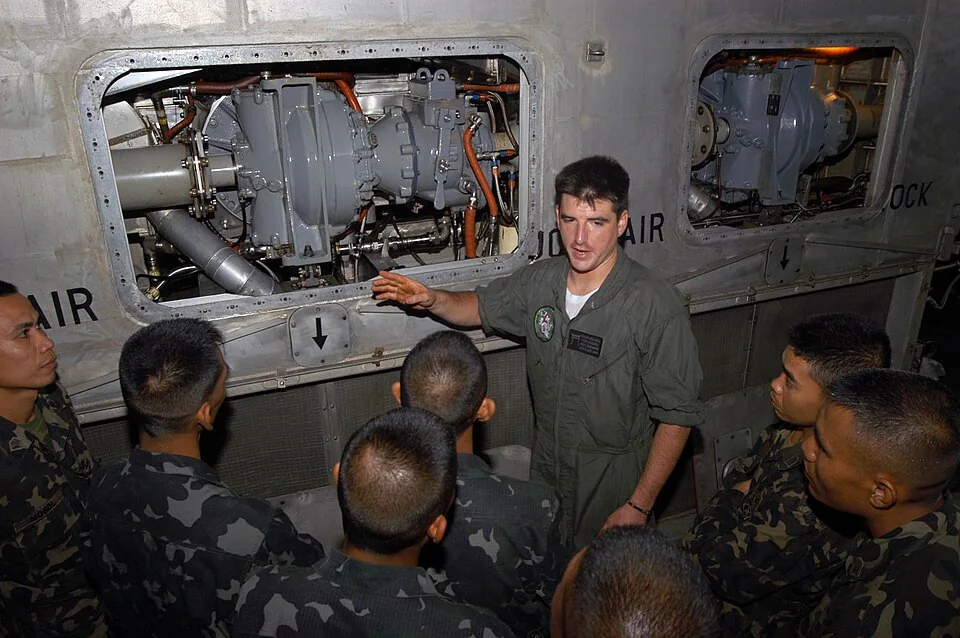 Technician explaining the gas turbine propulsion system of a naval landing craft
